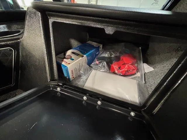 Slide: The Image of Storage compartment in a 2025 Crestliner 1750 Fish Hawk boat with various items inside. - 10
