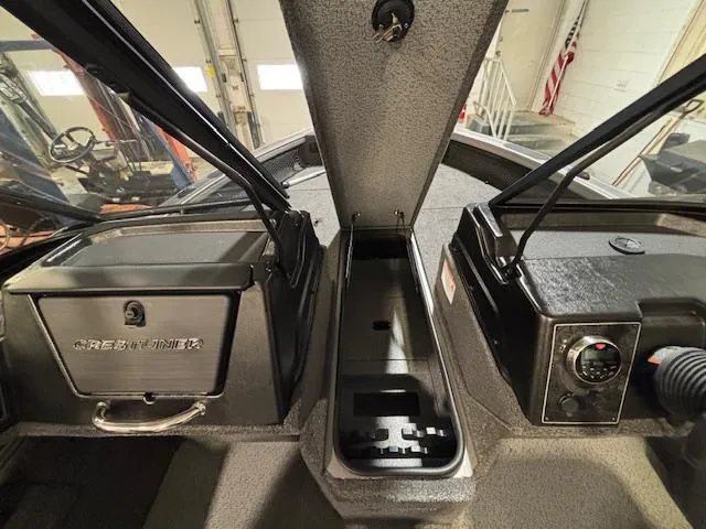 Slide: The Image of 2025 Crestliner 1750 Fish Hawk interior, featuring storage compartments and control panel. - 13