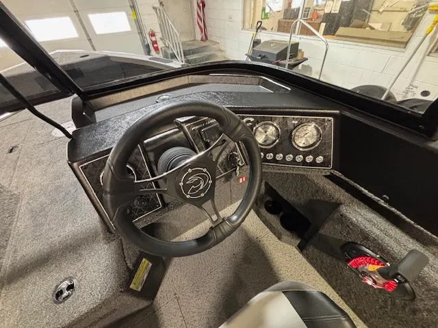 Slide: The Image of 2025 Crestliner 1750 Fish Hawk dashboard with steering wheel and gauges in a showroom. - 20