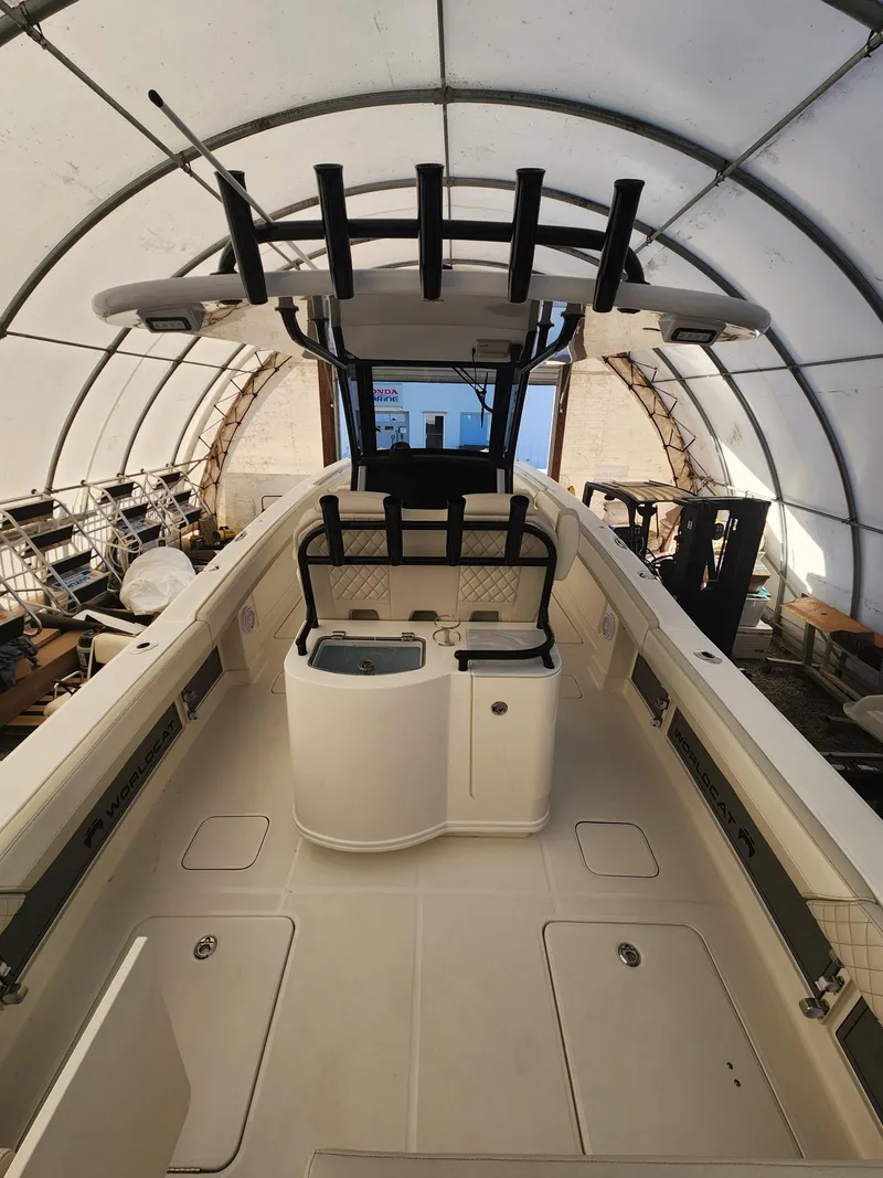 Slide: The Image of 2024 World Cat 280 CC-X boat interior under a canopy, showcasing spacious deck and seating. - 2