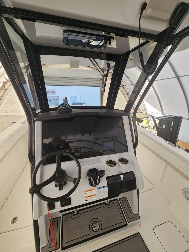 Slide: The Image of 2024 World Cat 280 CC-X boat cockpit with steering wheel and control panel. - 5