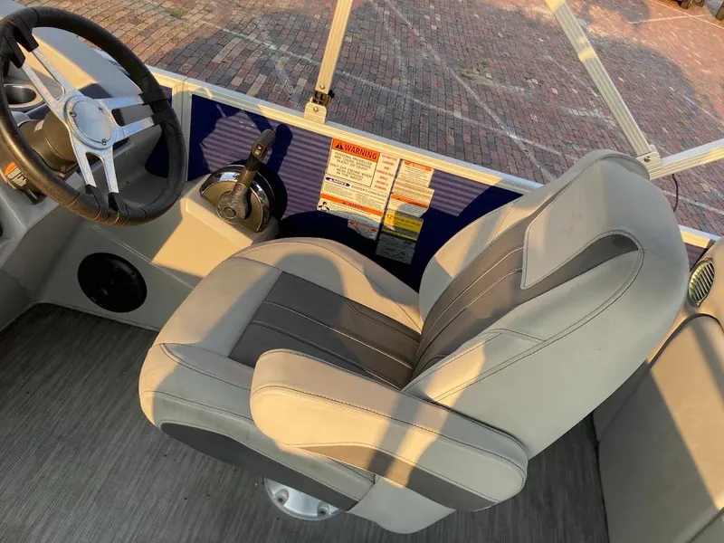 Slide: The Image of 2021 Bennington SX23 boat interior with steering wheel and captain's chair. - 14