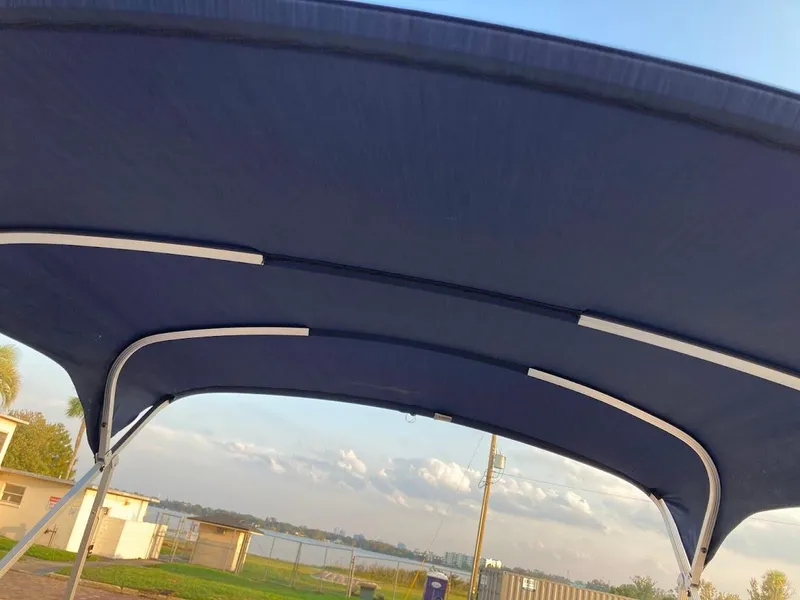 Slide: The Image of Blue canopy of 2021 Bennington SX23 boat with scenic background. - 22