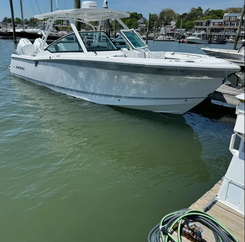 Slide: The Image of 2024 Blackfin 302 DC boat docked in a marina, featuring sleek design and dual engines. - 1