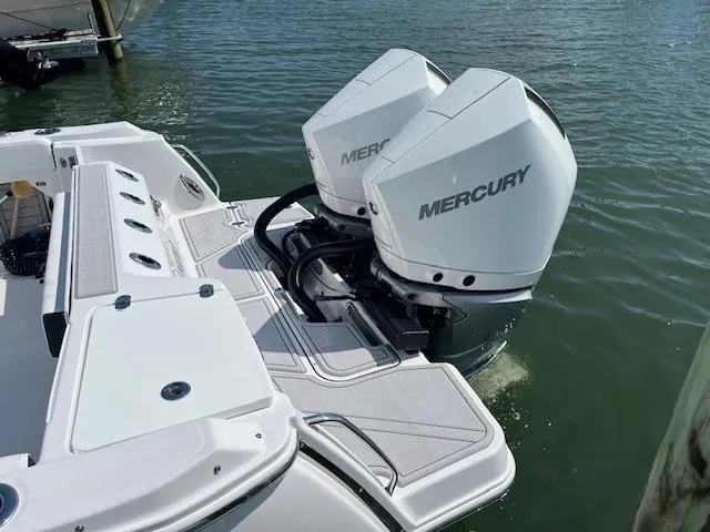 Slide: The Image of 2024 Blackfin 302 DC boat docked with canopy, sleek design, and spacious seating. - 3