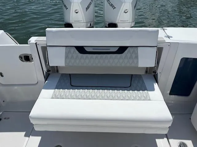 Slide: The Image of 2024 Blackfin 302 DC boat with white cushioned seating and dual Mercury engines. - 34