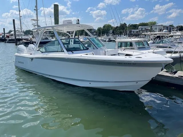 Slide: The Image of 2024 Blackfin 302 DC boat docked in a marina, surrounded by other vessels. - 9