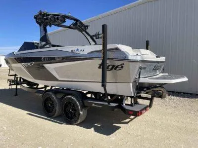 Slide: The Image of 2024 Tigé 22RZX boat on trailer, parked outdoors near a building. - 3