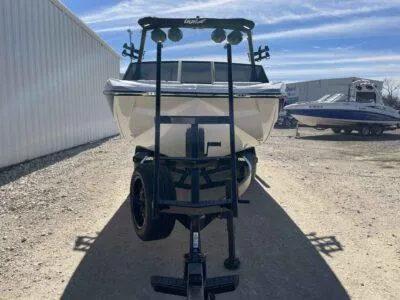 Slide: The Image of 2024 Tigé 22RZX boat on trailer, parked outdoors under a clear sky. - 6