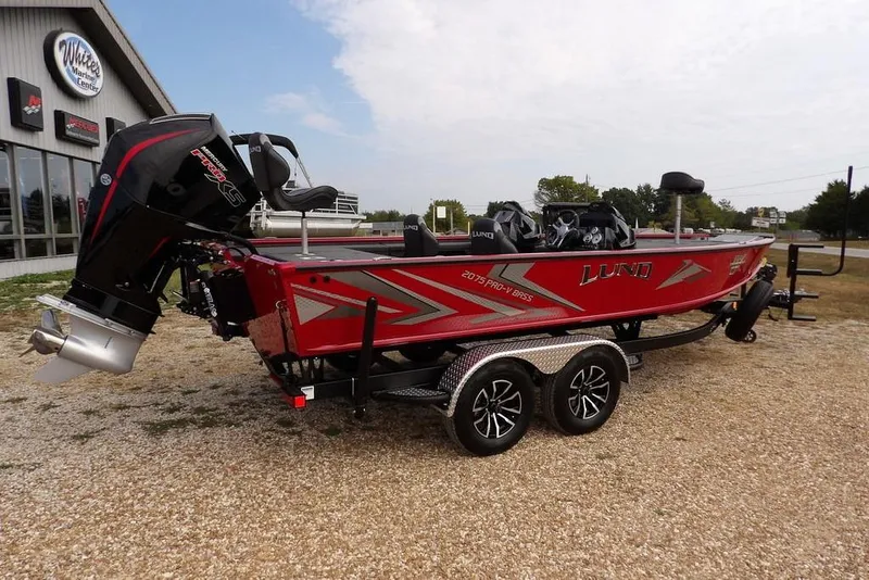 Slide: The Image of 2025 Lund 2075 Pro-V Bass XS boat on trailer, parked outside dealership. - 11