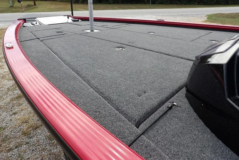 Slide: The Image of 2025 Lund 2075 Pro-V Bass XS boat deck with red trim and carpeted surface. - 14