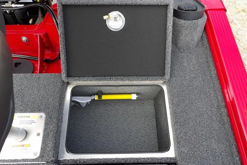 Slide: The Image of 2025 Lund 2075 Pro-V Bass XS boat storage compartment with yellow tool inside. - 19
