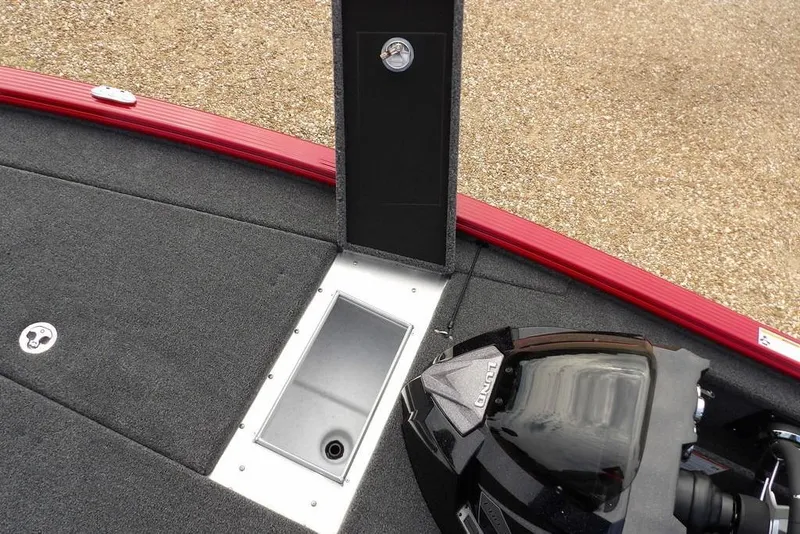 Slide: The Image of 2025 Lund 2075 Pro-V Bass XS boat interior with red trim and storage compartment. - 47