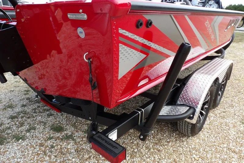 Slide: The Image of Red 2025 Lund 2075 Pro-V Bass XS boat on a trailer, featuring sleek design and graphics. - 54
