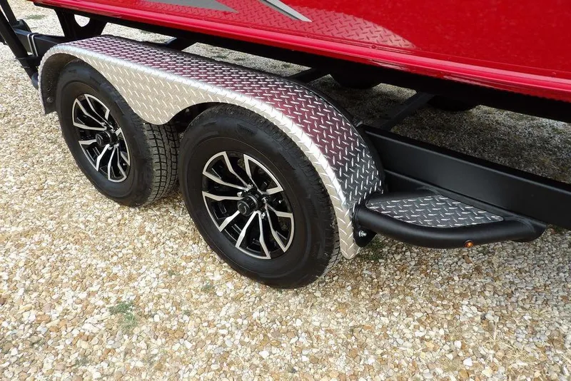 Slide: The Image of 2025 Lund 2075 Pro-V Bass XS trailer with dual wheels on gravel. - 55