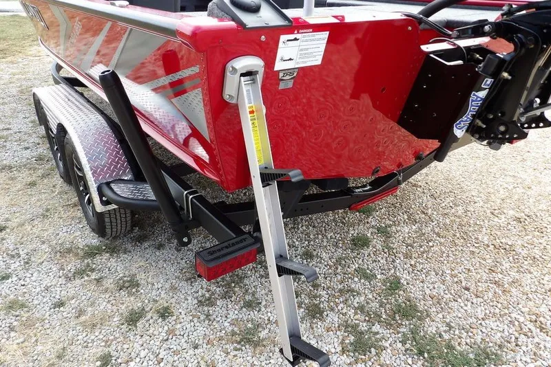 Slide: The Image of Red 2025 Lund 2075 Pro-V Bass XS boat on trailer with step ladder. - 66