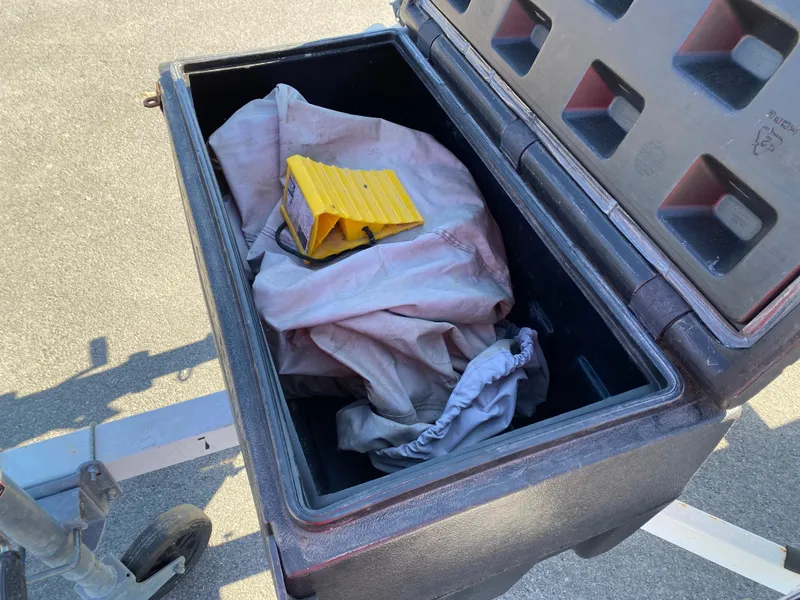 Slide: The Image of Open storage box with tarp and yellow wheel chock on pavement. - 4