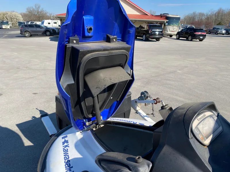 Slide: The Image of 2007 Kawasaki STX-12F jet ski with open storage compartment in a parking lot. - 6