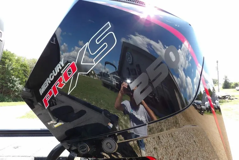 Slide: The Image of 2025 Lund 2075 Pro-V Bass XS boat on trailer, parked outdoors under clear sky. - 6