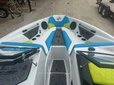 Slide: The Image of 2024 Tigé Z3 boat interior with blue and green seating, featuring speakers and cup holders. - 8