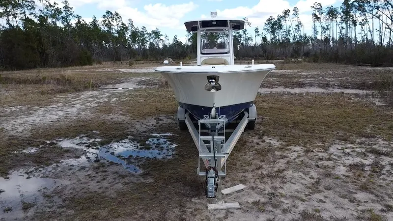 Slide: The Image of 2019 NauticStar 28 XS Offshore boat on trailer in a grassy area. - 10