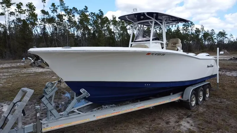Slide: The Image of 2019 NauticStar 28 XS Offshore boat on trailer, parked outdoors. - 11