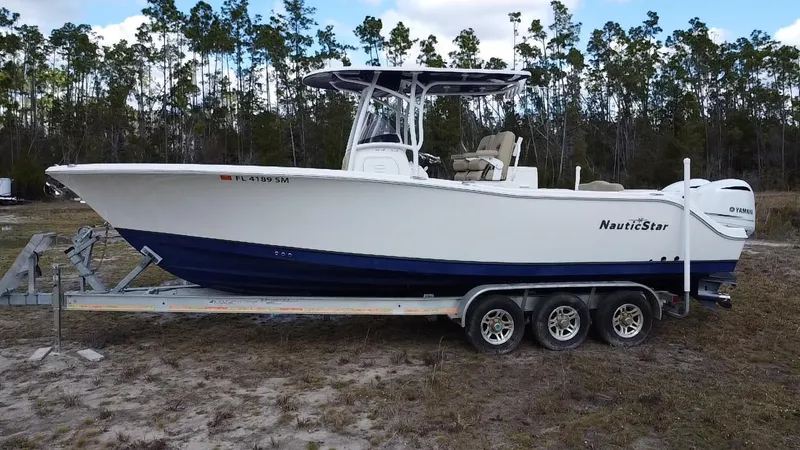 Slide: The Image of 2019 NauticStar 28 XS Offshore boat on trailer, parked outdoors. - 12