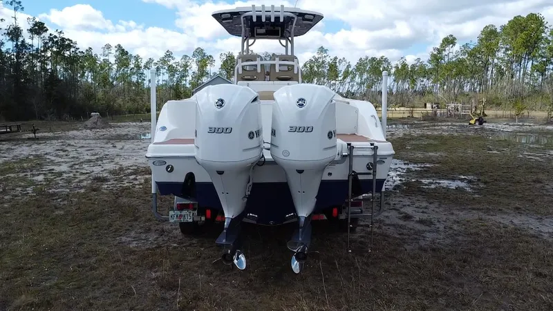 Slide: The Image of 2019 NauticStar 28 XS Offshore boat with twin 300 horsepower engines, parked on grass. - 14