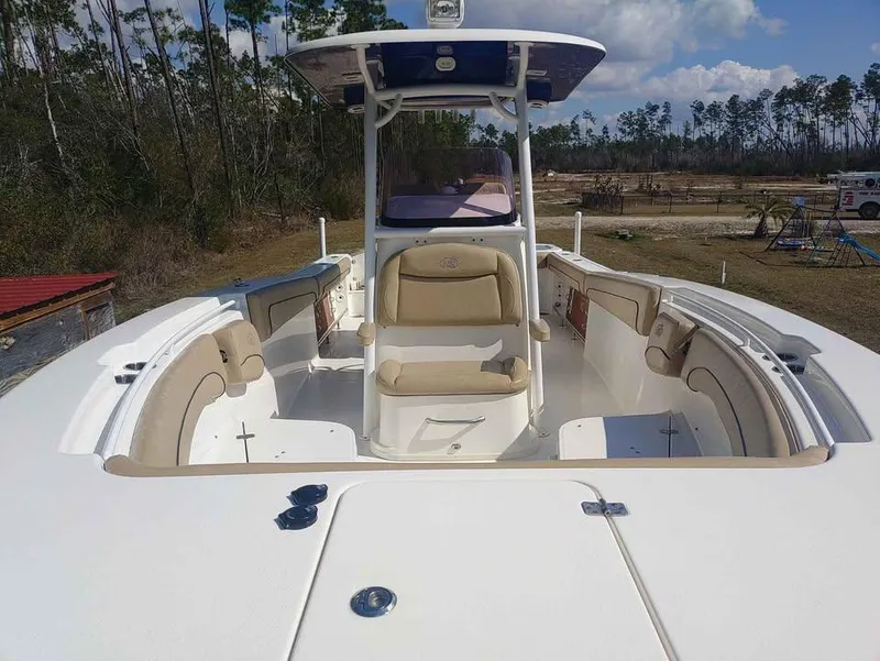 Slide: The Image of 2019 NauticStar 28 XS Offshore boat with seating, viewed from the bow, in a wooded area. - 21