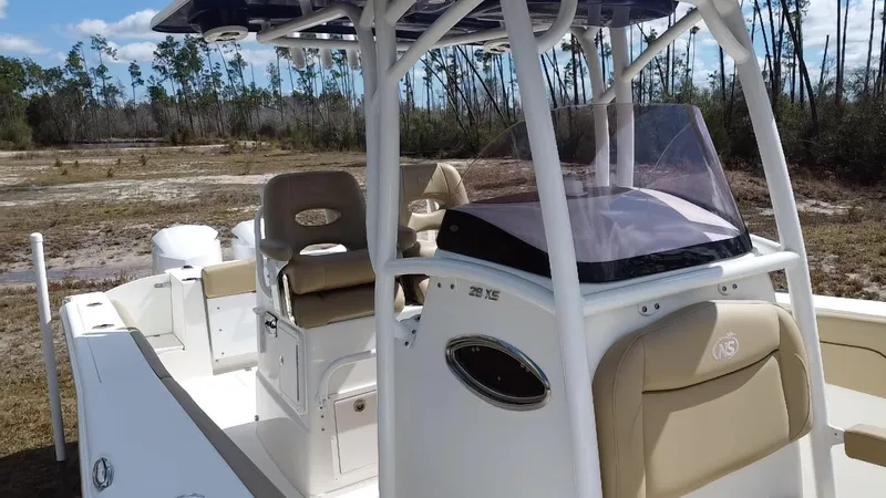 Slide: The Image of 2019 NauticStar 28 XS Offshore boat with beige seating, parked on land. - 25
