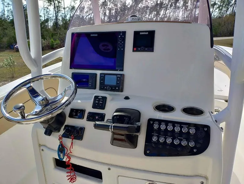 Slide: The Image of 2019 NauticStar 28 XS Offshore boat dashboard with steering wheel and electronic controls. - 26