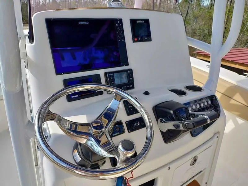Slide: The Image of 2019 NauticStar 28 XS Offshore boat helm with advanced navigation controls and steering wheel. - 27