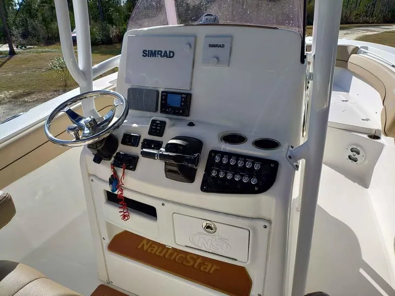 Slide: The Image of 2019 NauticStar 28 XS Offshore boat dashboard with Simrad electronics and steering wheel. - 28