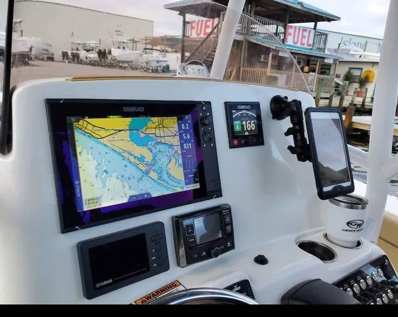 Slide: The Image of 2019 NauticStar 28 XS Offshore boat dashboard with navigation screens and controls. - 29