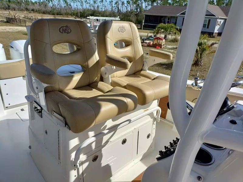 Slide: The Image of 2019 NauticStar 28 XS Offshore boat with tan captain's chairs and console. - 30