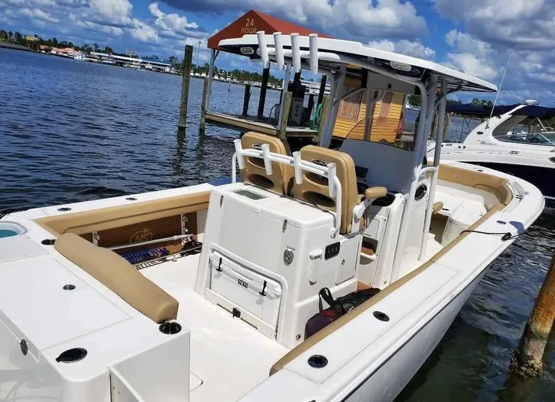 Slide: The Image of 2019 NauticStar 28 XS Offshore boat docked by the water. - 36