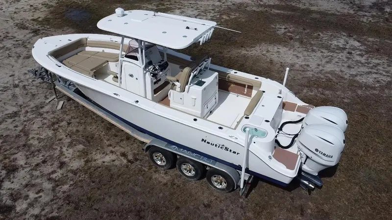 Slide: The Image of 2019 NauticStar 28 XS Offshore boat with dual Yamaha engines on a trailer. - 5