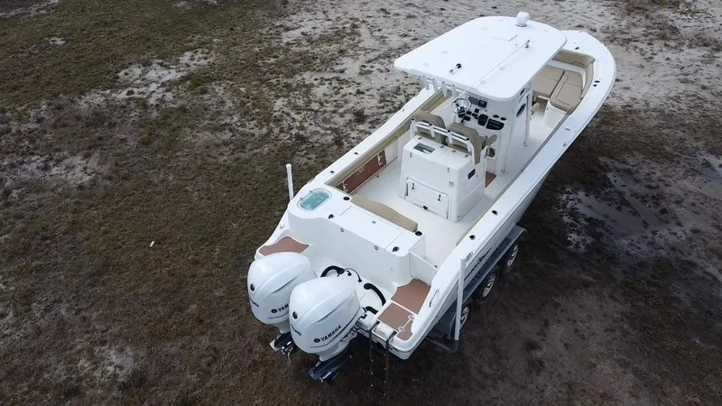 Slide: The Image of 2019 NauticStar 28 XS Offshore boat with dual engines on a trailer. - 7
