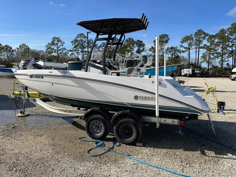 The Image of 2021 Yamaha Boats 210 FSH Sport on trailer, parked outdoors. - 1