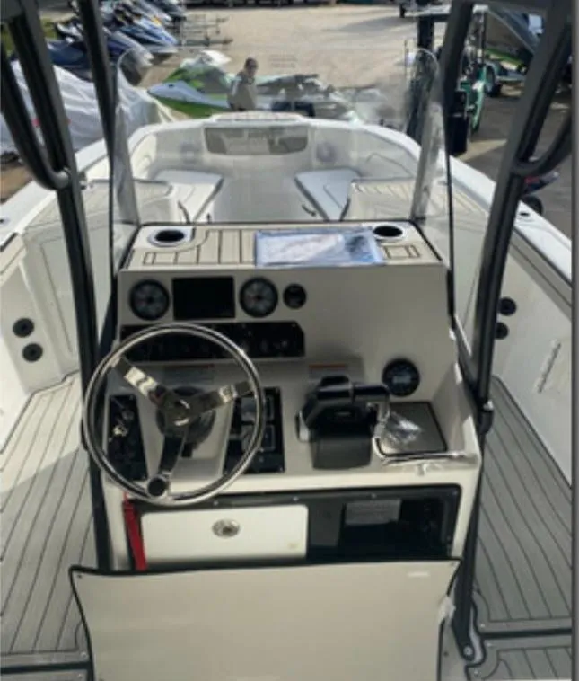 Slide: The Image of 2021 Yamaha Boats 210 FSH Sport interior with steering console and seating area. - 10