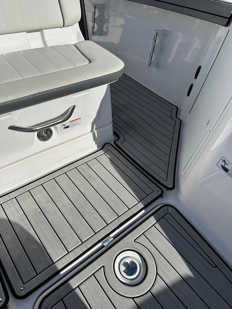 Slide: The Image of 2021 Yamaha Boats 210 FSH Sport interior with cushioned seating and non-slip flooring. - 15