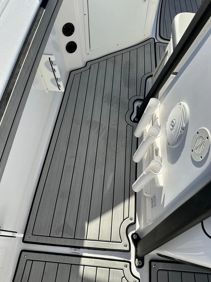 Slide: The Image of 2021 Yamaha Boats 210 FSH Sport deck with sleek, modern design and rod holders. - 25