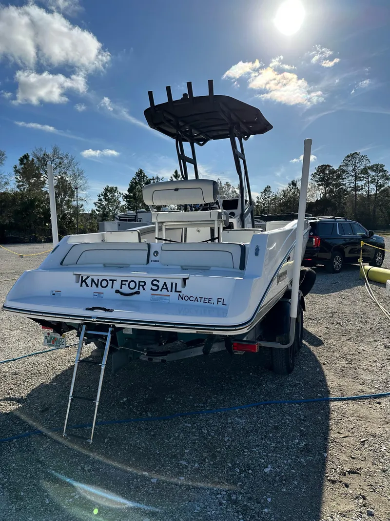 Slide: The Image of 2021 Yamaha Boats 210 FSH Sport on trailer, sunny day, "Knot for Sail" text on stern. - 29