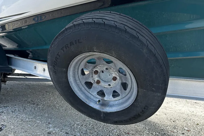 Slide: The Image of Trailer wheel of 2021 Yamaha Boats 210 FSH Sport on gravel surface. - 37