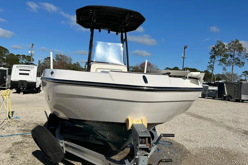 Slide: The Image of 2021 Yamaha Boats 210 FSH Sport on trailer, parked outdoors under clear blue sky. - 4