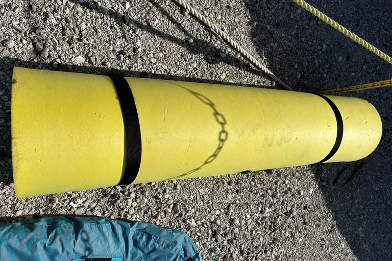 Slide: The Image of Yellow cylindrical object with black straps on gravel, near ropes and a blue item. - 41