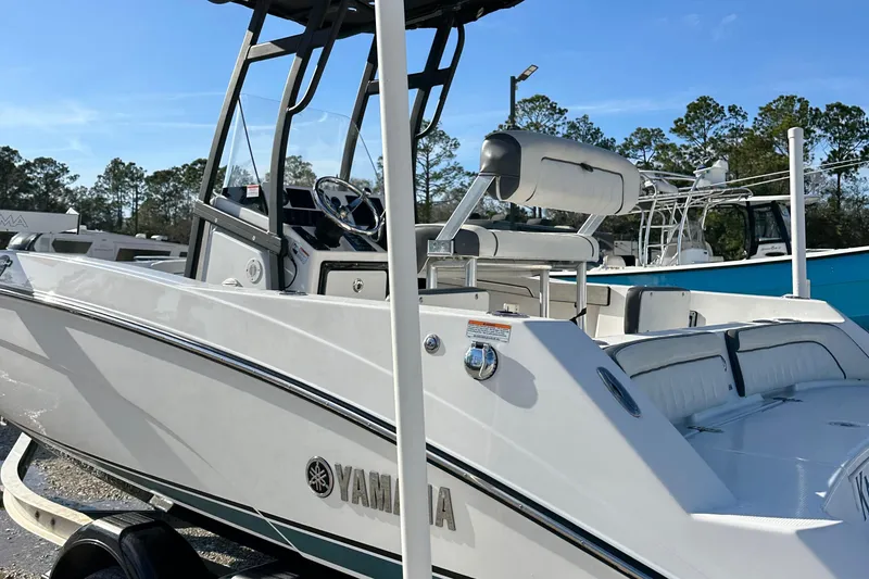 Slide: The Image of 2021 Yamaha Boats 210 FSH Sport, white exterior, parked outdoors, clear sky background. - 8