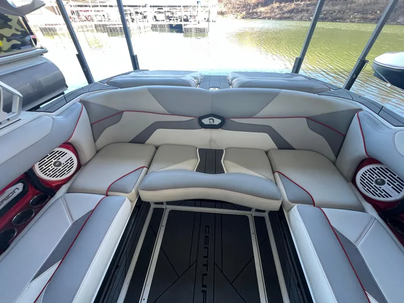Slide: The Image of 2022 Centurion Ri230 boat interior with gray and red seating, lake view in background. - 13