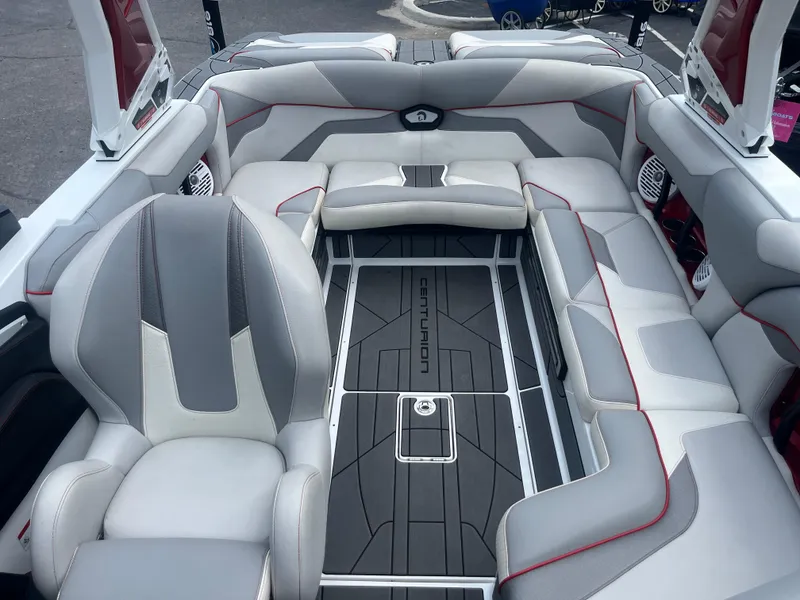Slide: The Image of 2022 Centurion Ri230 boat interior with gray and white seating, red accents, and branded flooring. - 18