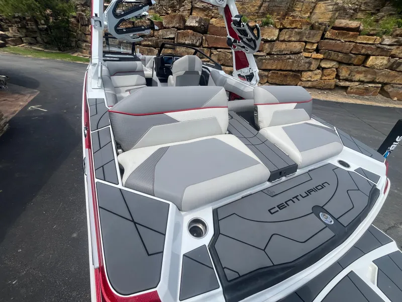Slide: The Image of 2022 Centurion Ri230 boat with sleek gray and white seating, docked outdoors. - 3